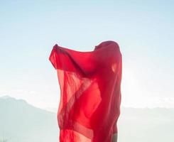 femme enveloppée dans une écharpe rouge au vent photo