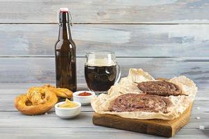 menu alimentaire pour l'oktoberfest. saucisse avec différentes sauces, bretzel et verre de bière brune photo