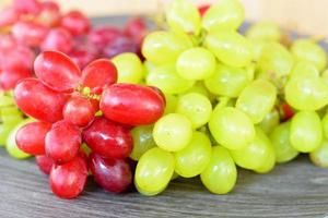 raisins naturels verts et rouges sur une plaque en bois