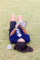 jeune fille allongée en train de lire. photo