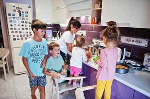 mère avec enfants cuisinant à la cuisine, moments heureux pour les enfants. photo