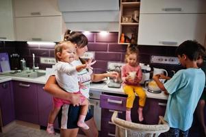 mère avec enfants cuisinant à la cuisine, moments heureux pour les enfants. photo