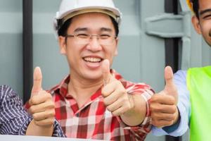 joyeux ingénieur et ouvrier d'usine équipe d'hommes souriants avec les pouces vers le haut en signe de succès photo