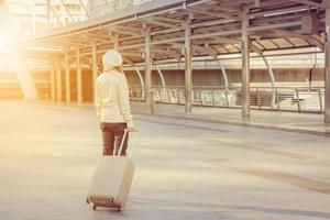 femme d'affaires voyageuse avec bagages au fond de la ville photo