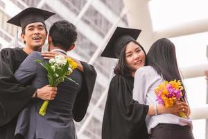 gros plan d'un jeune homme diplômé et d'une femme diplômée étreignant un ami à l'obtention du diplôme, concept d'éducation. photo