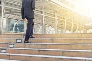 homme d'affaires avec smartphone en montant les escaliers au bureau. photo