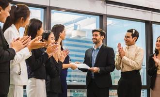 l'employé reçoit un certificat de réussite, les hommes d'affaires avec certificat au bureau, l'homme d'affaires donnant un certificat d'appréciation à l'employé pour sa réussite photo