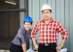 équipe de partenaires de projet du groupe de planification d'ingénieurs se réunissant sur le chantier, homme en casque debout et regardant la caméra sur le chantier de construction photo