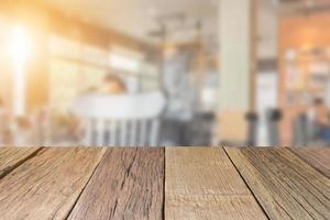 perspective de dessus de table en bois vide avec fond de café flou, utilisé pour le montage ou l'affichage de vos produits. photo