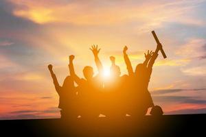 silhouette d'ingénieurs gens d'affaires célébration succès bonheur équipe au coucher du soleil fond de ciel du soir, avec un tracé de détourage. photo