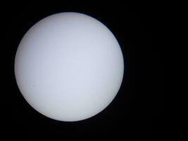 le soleil vu à travers un filtre solaire dans un télescope photo