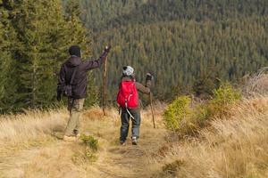 jeune couple randonneurs avec des tasses thermos en forêt, voyageurs dans les mauntains buvant du thé ou du café photo