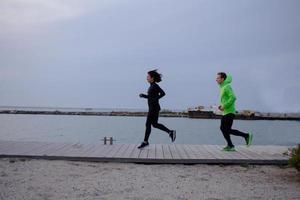 groupe de jeunes s'entraînant à l'extérieur, exercices de coureurs, arrière-plan mer ou rivière photo