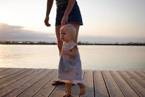 mère et fille marchant sur la jetée en bois aux beaux jours, famille heureuse sur la plage photo