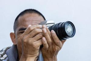 gros plan isolé d'un homme thaïlandais tenant un grand appareil photo reflex numérique avec un zoom noir.