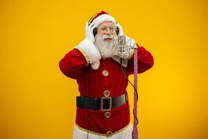 le père noël chante ou parle dans un microphone de studio. joyeux Noël. diffuseur. annonceur. promotion. concept de musique de noël. photo