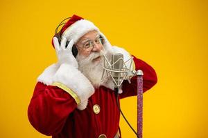 le père noël chante ou parle dans un microphone de studio. joyeux Noël. diffuseur. annonceur. promotion. concept de musique de noël. photo