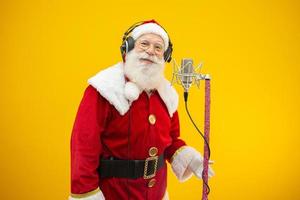 le père noël chante ou parle dans un microphone de studio. joyeux Noël. diffuseur. annonceur. promotion. concept de musique de noël. photo