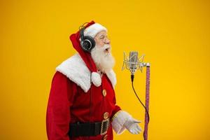 le père noël chante ou parle dans un microphone de studio. joyeux Noël. diffuseur. annonceur. promotion. concept de musique de noël. photo