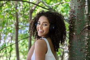 belle fille afro-américaine écoutant de la musique dans un parc photo