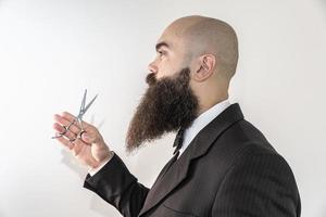 barbier avec une longue barbe à l'aide de ciseaux photo