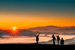 image silhouette de voyageurs hommes et femmes prenant des photos avec le lever du soleil le matin sur fond naturel de montagnes.