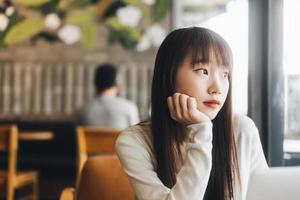 jeune adulte asiatique femme étudiante au café intérieur le jour. photo