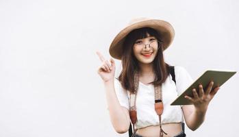 jeune fille souriante asiatique porte des lunettes tenant une table pour un voyage intelligent. photo