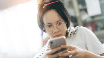 jeune adulte seule femme célibataire utilisant un téléphone portable le matin pour la télémédecine et la santé mentale. photo