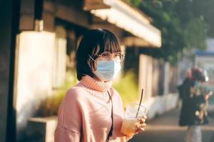 jeune adulte asiatique lunettes femme porter un masque facial pour protéger le virus corona ou covid19.