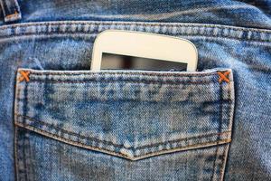 partie de téléphone portable dans la poche arrière d'un jean bleu photo