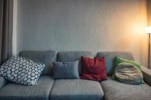 canapé moderne en tissu gris avec oreillers et lampe d'éclairage photo
