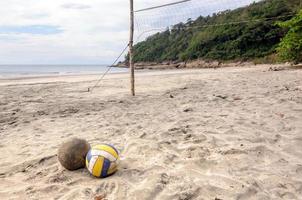 Beach-volley. volley-ball sur le sable sous la lumière du soleil et le ciel bleu. photo