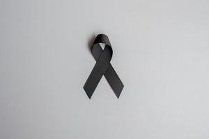 mélanome et cancer de la peau, mois de sensibilisation aux blessures causées par les vaccins et concepts de repos en paix. ruban noir sur fond gris photo