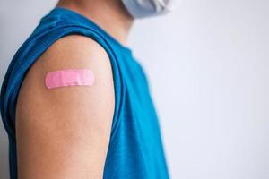 homme montrant un bandage après avoir reçu le vaccin covid 19. vaccination, immunité collective, effet secondaire, dose de rappel, passeport vaccin et pandémie de coronavirus photo