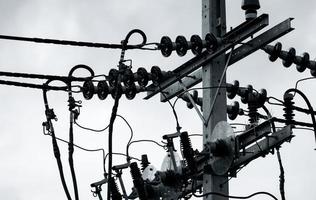 scène en noir et blanc de l'énergie électrique triphasée pour le transfert d'énergie par les réseaux électriques. énergie électrique pour soutenir l'industrie manufacturière. poteaux électriques et lignes électriques à haute tension. photo