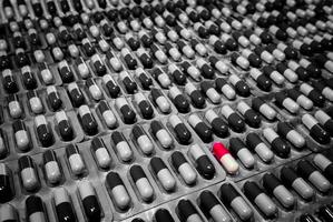 capsule rouge et blanche en capsule monochrome pilule sous blister. capsule exceptionnelle dans la pilule de la foule. sélection des médicaments à l'hôpital. dangers de l'utilisation de médicaments sans consulter le concept d'un médecin ou d'un pharmacien.