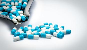 capsules bleues et blanches pilules et plateau de médicaments sur fond blanc avec espace de copie pour le texte. concept de soins de santé mondial. concept de résistance aux antibiotiques. gélules antimicrobiennes. photo