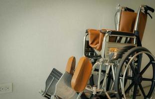 fauteuil roulant vide près du mur à l'hôpital pour les patients de service et les personnes handicapées. équipement médical à l'hôpital pour aider les personnes âgées. chaise à roulettes pour les soins aux patients en maison de retraite. photo