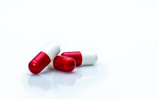 Détail de macro shot de pilules de capsule d'antibiotiques rouges et blancs isolés sur fond blanc avec espace de copie. utilisation d'antibiotiques avec un concept raisonnable. concept de résistance aux antimicrobiens. photo
