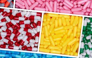 voir ci-dessus les pilules de capsule dans une boîte en plastique. pilules de capsule multicolores. concept de vitamines et de suppléments. industrie pharmaceutique. produits pharmaceutiques. la santé et la médecine. fabrication pharmaceutique. photo