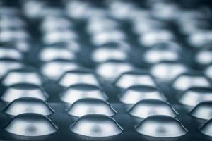 comprimés comprimés sous blister de papier d'aluminium argenté. industrie pharmaceutique. de nombreux emballages sous blister de pilules avec lumière. médicaments pour le traitement de la maladie. concept de pharmacologie et de pharmacie. photo