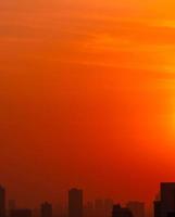 ville le matin avec le ciel rouge du lever du soleil et le smog. la pollution de l'air. paysage urbain avec de l'air pollué. poussières toxiques urbaines. air malsain. mode de vie malsain. notion de changement climatique. pollution environnementale. photo