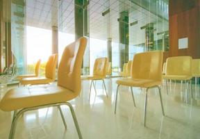 concept de distanciation sociale. chaise jaune vide d'affilée avec espace pour la distance sociale pour empêcher le coronavirus covid-19 dans la salle d'attente de l'hôpital pour les patients en attente. chaise publique à l'hôpital. photo