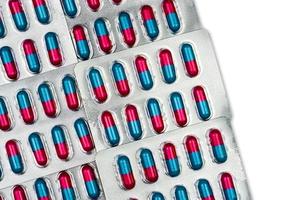 coloré de capsule bleue, rose avec granule dans les pilules latérales. pilules sous blister sur fond blanc avec espace. forme galénique et conditionnement pharmaceutique. médicament antifongique. photo