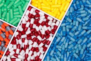 vue de dessus des pilules de capsules colorées dans un plateau en plastique. industrie pharmaceutique. la santé et la médecine. production de drogue. notion de pharmacie. capsules de vitamines et de suppléments. capsule de couleur vive. photo