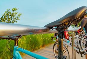 vélo garé sur un support en aluminium au parc. activités d'exercice et de loisirs en plein air. vélo à la station de stationnement pour vélos. respectueux de la nature. mode de vie sain. activité de plein air en été. sport extrême. photo