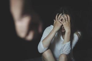 femme assise tenant sa tête le concept d'être maltraité physiquement et mentalement dépression, stress, problèmes mentaux violence familiale et traite des êtres humains. photo