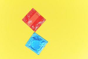 préservatif isolé sur fond jaune pack de préservatifs colorés pour le contrôle des naissances moyens contraceptifs prévenir la grossesse ou les maladies sexuellement transmissibles photo