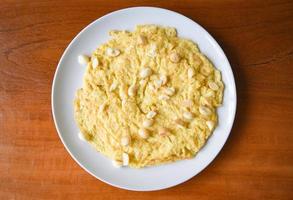 petit-déjeuner omelette aux noix de macadamia sur le dessus sur une assiette blanche des aliments sains photo